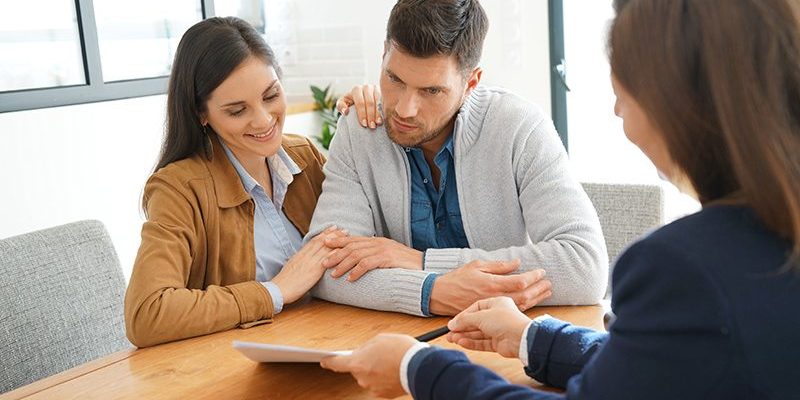 Couple meeting financial adviser for home investment contract